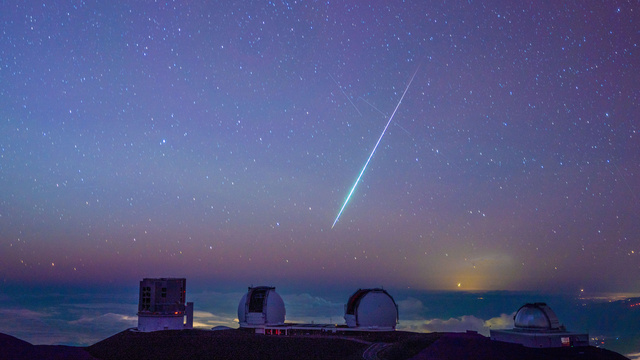 すばる望遠鏡（左）など望遠鏡群と流れ星=11日、米ハワイ島・マウナケア山頂、東山正宜撮影