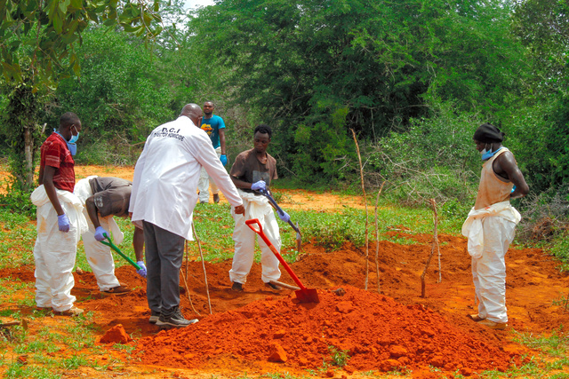 ケニア東部シャカホラの森で4月25日、捜査当局による遺体の掘り起こしをボランティアたちが手伝っていた=ロイター