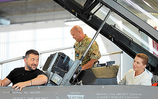 デンマークの空軍基地で２０日、戦闘機Ｆ１６に乗り込んだウクライナのゼレンスキー大統領（左）とデンマークのフレデリクセン首相（右）＝ロイター