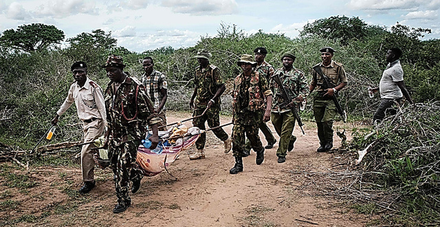 ４月２３日、ケニア東部にある教団の聖地「シャカホラの森」から救助された若い男性を運び出す治安関係者たち＝ＡＦＰ時事