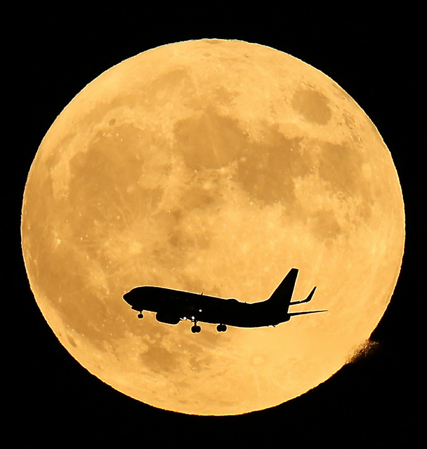 中秋の名月を横切る飛行機＝２９日午後６時１８分、大阪市、西畑志朗撮影