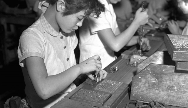 1955年、長野県諏訪市の三協精機工場でオルゴールを作る工員。ゼンマイのケースを鋳物のフレームにビス留めしている。