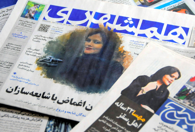 イランで昨年9月、ヒジャブの着用をめぐり逮捕後、急死したマフサ・アミニさんの事件について報じる地元紙=2022年9月20日、飯島健太撮影
