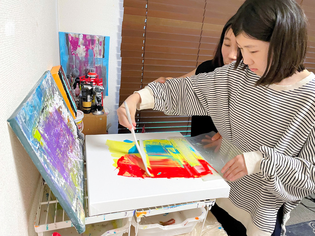 絵を描く柳端娥さん（右）。母の高賢鮮さんがサポートすることも=2023年10月8日午後4時31分、名古屋市、浦島千佳撮影