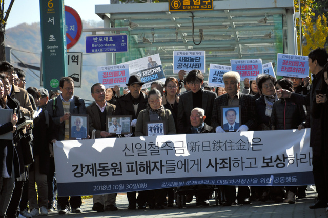 故人となった元徴用工の遺影を掲げ、韓国大法院を目指す原告たち=2018年10月30日、ソウル、武田肇撮影