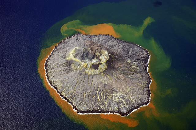 2013年の噴火から10年を迎える西之島。周辺海域は噴火の影響で変色していた=2023年11月3日、東京都小笠原村、朝日新聞社機から、恵原弘太郎撮影