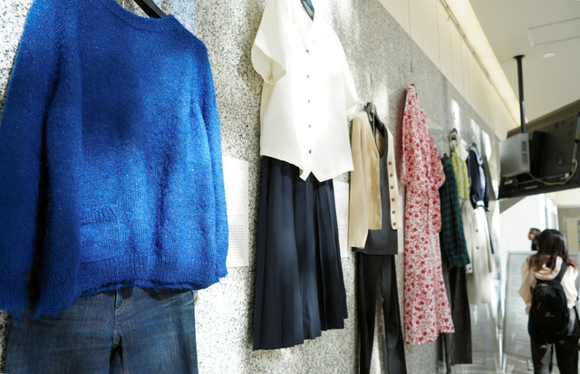 「そのとき、あなたは、何を着てた？」展で展示されたブルーのニットとジーンズ、シャツとスカートなど=東京・四谷の上智大学