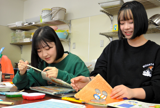 絵本を修理する学生たち=2023年12月8日、愛知県尾張旭市、浦島千佳撮影