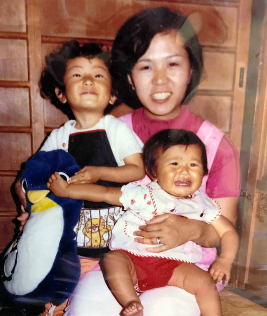 神戸市長田区の自宅で母の上垣政代さんに抱かれる幼少期の美紀さん（右）と規子さん（左）。政代さんと美紀さんは阪神・淡路大震災で亡くなった=遺族提供