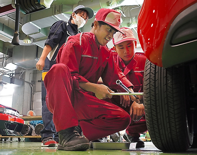 日本人の教師（左奥）から自動車整備を学ぶネパールや中国籍の生徒たち＝２０２３年１１月８日、東京都大田区、小玉重隆撮影