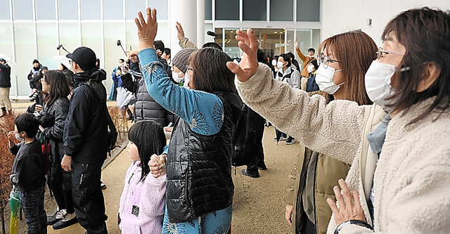集団避難する中学生が乗るバスを見送る家族ら＝２１日午前、石川県珠洲市、細川卓撮影