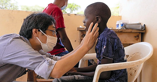 マラリアに罹患し、診療所を訪れた少年（右）と治療にあたる筆者＝２０２３年２月８日、ザンビア・セントラル州ムアプラ村診療所で、上山敦司さん撮影（画像の一部にモザイクをかけています）