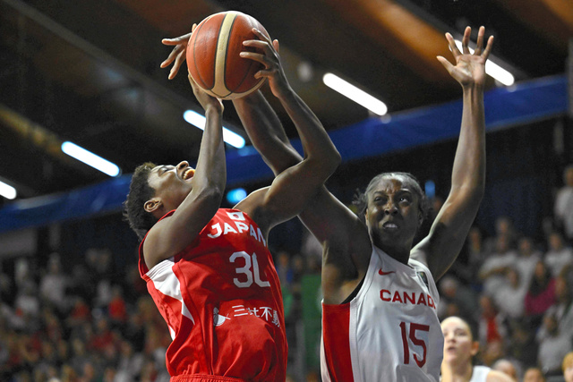 バスケットボールのパリ五輪世界最終予選のカナダ戦で、果敢に攻め込む日本の馬瓜エブリン（左）=AFP時事