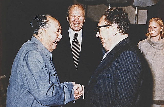 １９７５年、北京で毛沢東と握手するキッシンジャー（右）。毛沢東はソ連とも関係改善を図ろうとするキッシンジャーに不信感を抱いていたとされる＝ロイター