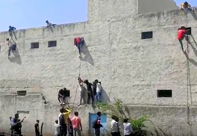 インドの地元週刊誌「インディア・トゥデー」の電子版が6日公開した動画では、建物の屋上からロープでぶら下がったり、地上から壁をよじ登ったりして、2階以上の窓から内部をのぞき込む人の様子が映しだされていた=インディア・トゥデー