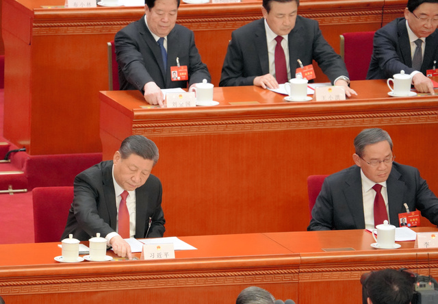 全人代最終日の2024年3月11日、議案が表決にかけられ、ボタンを押す習近平国家主席（前列左）=北京の人民大会堂、金順姫撮影