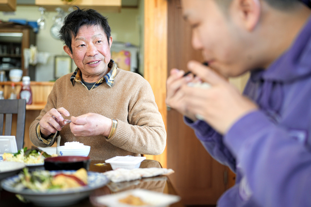 宿泊客と朝食を食べる「まがき」の店主、遠藤仁雄さん（左）=2024年3月11日、宮城県石巻市、竹花徹朗撮影