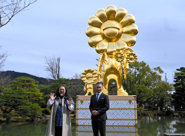 巨大彫刻「お花の親子」の前に立つ村上隆さん（左）とルイ・ヴィトンのアンバサダーの十三代目市川團十郎さん=2024年3月12日、京都市左京区の京都市京セラ美術館、西田健作撮影