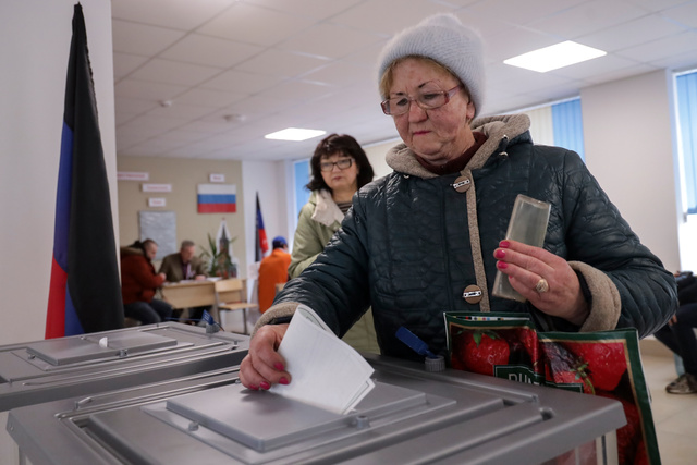 ロシアが一方的に併合し、実効支配するウクライナ東部ドネツク州マリウポリで2024年3月17日、ロシア大統領選の投票をする女性=AP