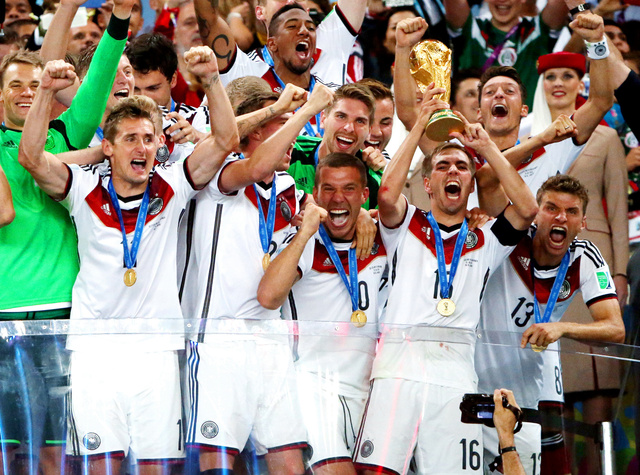 ワールドカップトロフィーを掲げ、喜びを爆発させるドイツの選手たち=2014年、上田潤撮影。ユニホームには、アディダスの3本線が刻まれている。