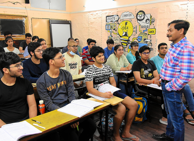 インドの首都ニューデリー近郊にある進学塾に通う生徒に指導するバグワン・グプタ代表（右）＝２０２３年１０月