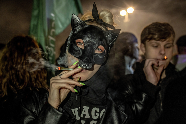 ドイツで大麻の使用や所持が合法化された2024年4月1日、首都ベルリンのブランデンブルク門前で大麻を吸う人々=AP