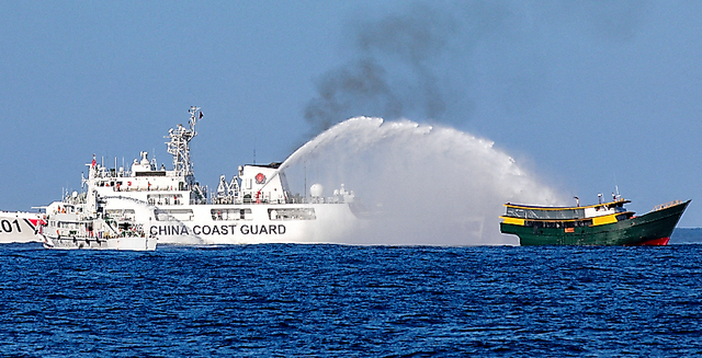 南シナ海で３月５日、アユンギン礁へ補給に向かうフィリピン船（右）に放水する中国海警局の船＝ロイター