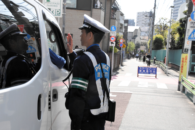 スクールゾーンに進入した車に声をかける警察官=2024年4月15日午前8時23分、東京都大田区蒲田、御船紗子撮影