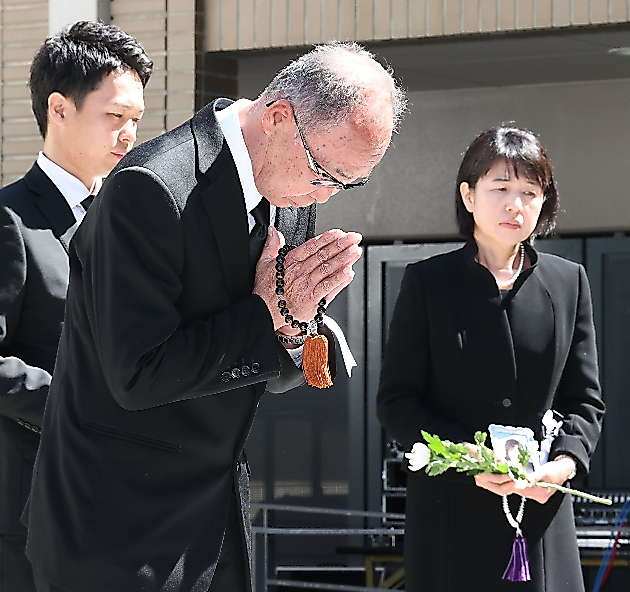 追悼式で献花し、手を合わせる大和晃さんの父卓也さん（中央）。右は母忍さん＝４月１４日午前１０時１１分、熊本市、小宮路勝撮影