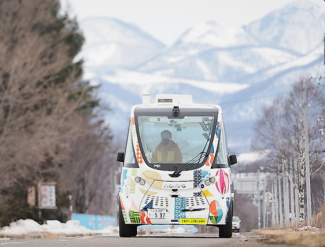町の中心部に向かって走行する自動運転バス＝２月１５日、北海道上士幌町