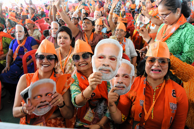 与党連合の選挙集会に参加する女性たち。モディ首相のお面をかぶる支持者もいた=2024年3月31日、インド北部メーラト、石原孝撮影