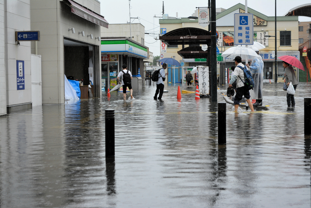昨年6月の越谷市であった大雨による浸水被害では、人々が裸足で路上を行き来していた=2023年6月3日