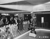 渋谷区の東京都児童会館を訪れ、子どもたちと一緒にロボットを視察する皇太子さまと美智子さま。左後方和服の女性は、皇籍離脱前に同所の宮邸に住んでいた梨本伊都子さん。左端は牧野純子東宮女官長