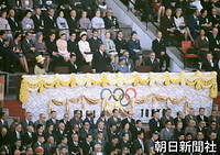 １０月１０日　東京五輪開会式で開会を宣言する昭和天皇。後方に皇太子ご夫妻らの姿も