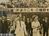 第２４回長崎国民体育大会夏季大会の開会式で、観衆の歓迎に応える皇太子さまと美智子さま。佐世保市総合グラウンドプールで