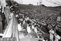 ７月、第１回日米大学野球選手権大会の始球式で、米国のバニスター主将に向かってボールを投げる皇太子さま。右下は日本の萩野主将。東京・神宮球場で