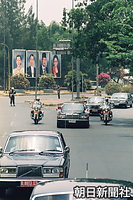 天皇、皇后両陛下とスハルト大統領夫妻の肖像画が並ぶジャカルタ市内を走る両陛下の車列