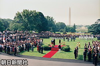 ホワイトハウス南庭で行われた歓迎式典。赤じゅうたんの式台上にクリントン米大統領と天皇陛下。右後ろが皇后さまとヒラリー夫人、正面に整列するのは４軍の儀仗兵、奥の尖塔がワシントン・モニュメント。白昼でもカ