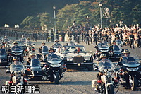 １９９０年１１月、天皇陛下即位の礼で、皇居から当時のお住まいだった赤坂御所に向かう「祝賀御列の儀」で、皇居前を走る両陛下の車列。ロールス・ロイスのオープンカーの周囲を皇宮警察の白バイとサイドカーが護衛