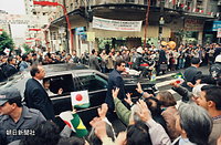 日の丸とブラジル国旗が振られる沿道の人々に手を振って応える皇后さま。日本では考えられない距離だ