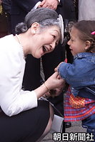 アムステルダムの小児身体障がい者施設「ミチルスクール」を訪問し、手に持った髪留めを見せる女の子に話しかける皇后さま