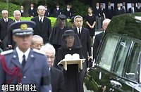 東京都文京区の豊島岡墓地で行われた「斂葬（れんそう）の儀」で、葬場殿に向かう霊轜（れいじ＝ひつぎを載せた車）と天皇、皇后両陛下の徒歩列。皇后さまの左は渡辺允侍従長