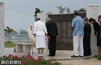 マリアナ記念碑に供花、黙とうされる天皇、皇后両陛下。右に立つのは２人の遺族代表。碑に刻まれているのは戦没者の名前