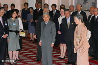 英国・ロンドンの日本大使館で在留日本人代表と接見、招待者の前でなごやかな笑顔の天皇、皇后両陛下。両陛下の間は野上義二・英国大使。壁際に立つのは、右からノーベル化学賞受賞者の野依良治首席随員、羽毛田信吾