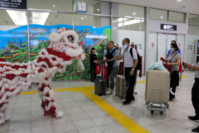 再開した大連・北京便で到着した旅行客を、中国の獅子舞が出迎えた=2023年8月25日午後2時55分、広島空港、西本秀撮影