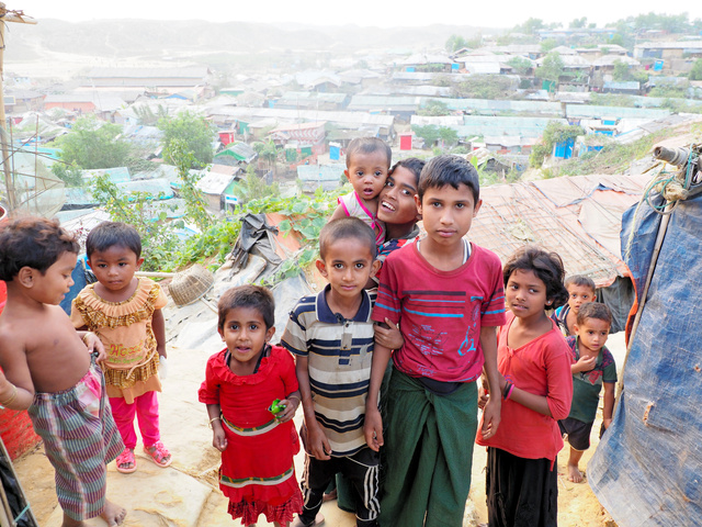 バングラデシュ南東部コックスバザールにある難民キャンプ。ロヒンギャの子どもたちの後ろに、丘陵地に立つ家々が見える=2020年1月、奈良部健撮影