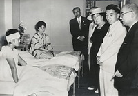 広島の原爆病院を訪れ、中山マサ厚相（帽子の女性）や重藤院長（右端）らと患者の大浦勝子さん（左）と品川ヤス子さん（中央）を見舞う皇太子さま