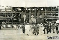インドネシアのジャカルタに到着し、巨大な肖像画が掲げられた空港での歓迎式典へ向かう皇太子さま、美智子さま。右はスカルノ大統領