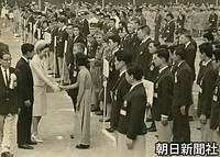 １０月　東京オリンピック世界青少年キャンプ開村式で、ベトナム代表（中央）と握手する美智子さま。左は皇太子さま。東京都世田谷区の東京学芸大学世田谷校舎で