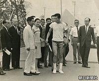 ユニバーシアード東京大会名誉総裁の皇太子さまと美智子さまが代々木にある選手村を訪問、香港バスケットボールチームのトニー・タン選手と話す
